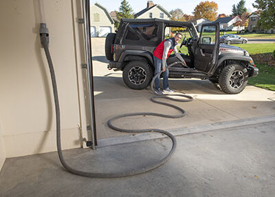 Vroom Retract Vac cleans Jeep in driveway